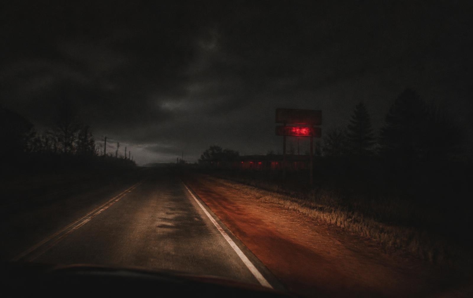 Empty Southern back road at night lit by headlights
